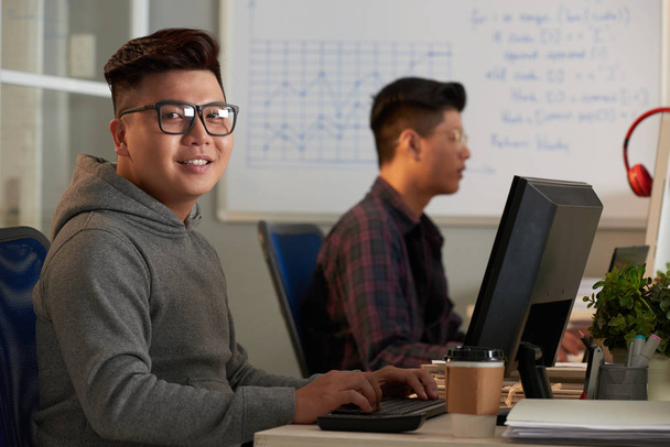 двоє азіатських студентів працюють за комп'ютерами
 - Фото, зображення