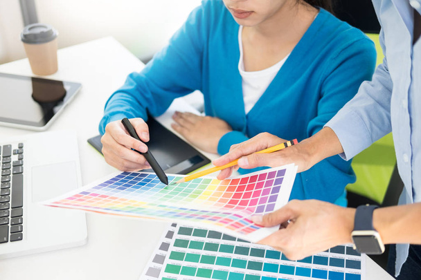 Yaratıcı veya pantone renk örneği ve planları ofis masası üzerinde bina ile iç tasarımcılar ekip çalışması mimarlar tasarım projesi bir masaüstü bilgisayar ve bazı renk örneklerini kullanarak seçim seçerek renk örnekleri - Fotoğraf, Görsel