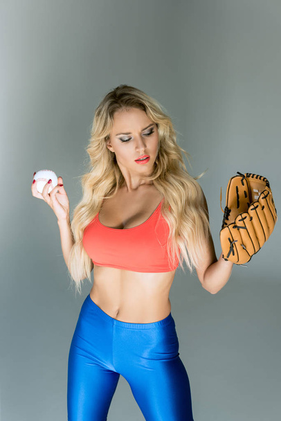ταιριάζει νεαρή γυναίκα σε αθλητικά είδη με Μπέιζμπολ γάντι και μπάλα  - Φωτογραφία, εικόνα