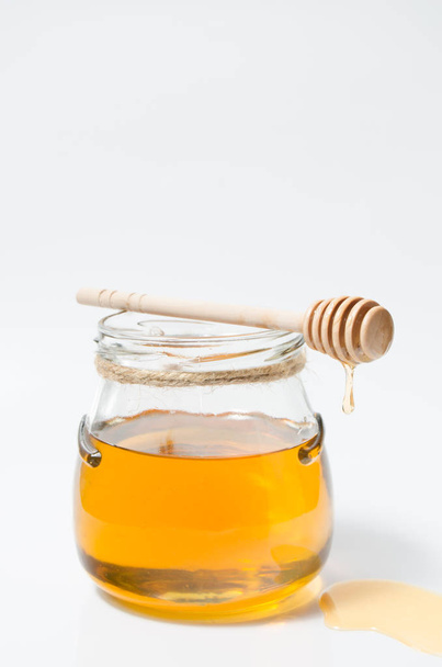Natural fresh honey and honey spoon on white background.Close up. - Foto, immagini