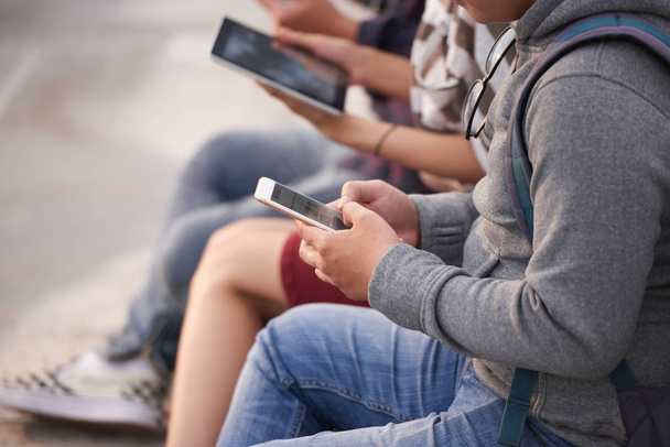 Groupe d'étudiants asiatiques assis à l'extérieur et surfer sur Internet sur des tablettes numériques modernes
 - Photo, image