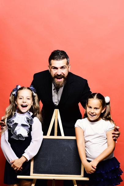 Girls and man with happy faces. Bearded teacher and kids - Φωτογραφία, εικόνα