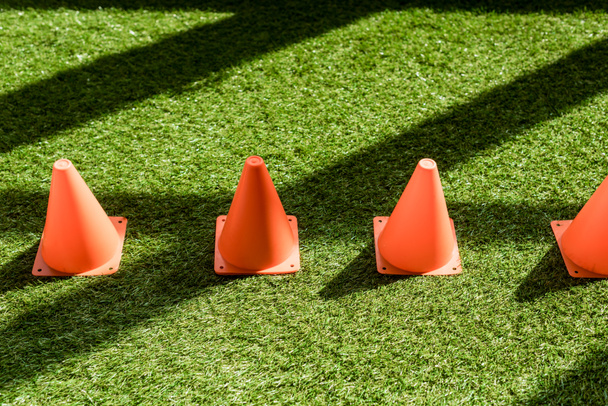 high angle view of row of safety cones standing on grass field - 写真・画像
