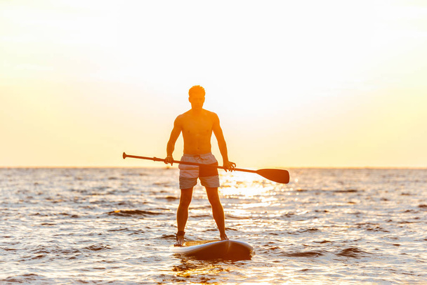 Image of young handsome man kayaking on lake sea. - Fotó, kép