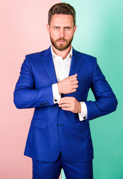 Man well groomed businessman with beard strict face check button on shirt sleeve. Make sure outfit and appearance look perfect. Details make outfit elegant. Male fashion. Perfect to last detail - Foto, afbeelding