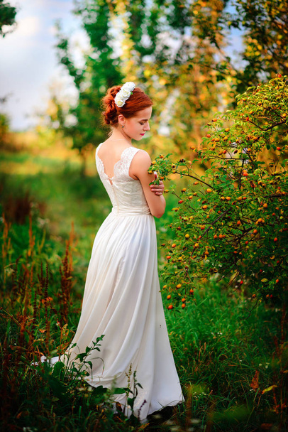 Junge schöne blonde Frau im blühenden Garten. Braut - Foto, Bild