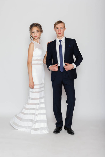 young fashion couple on a gray background in studio - Zdjęcie, obraz