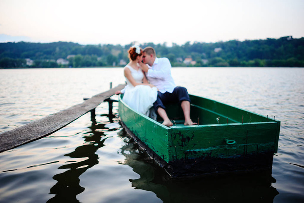 young couple in love sitting in a small boat and having fun. - Φωτογραφία, εικόνα