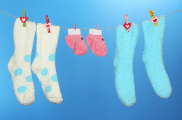 Colorful socks hanging on clothesline, on color background - Φωτογραφία, εικόνα