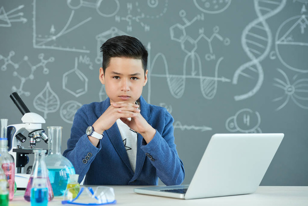 Portrait shot of confident teenage pupil looking at camera, chemistry classroom - Photo, Image