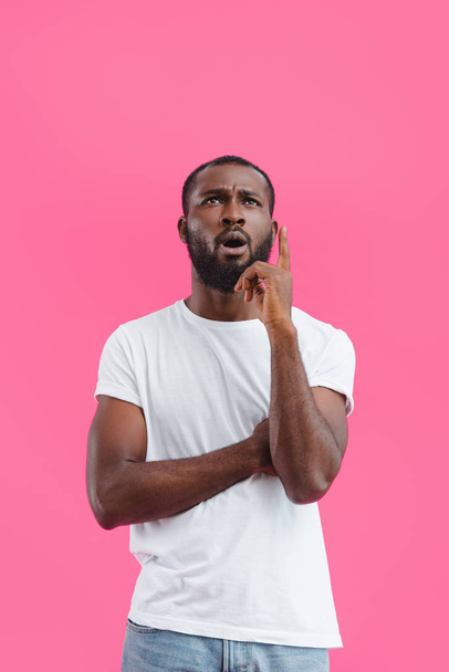 portrait of pensive african american man in white shirt isolated on pink  - Photo, Image