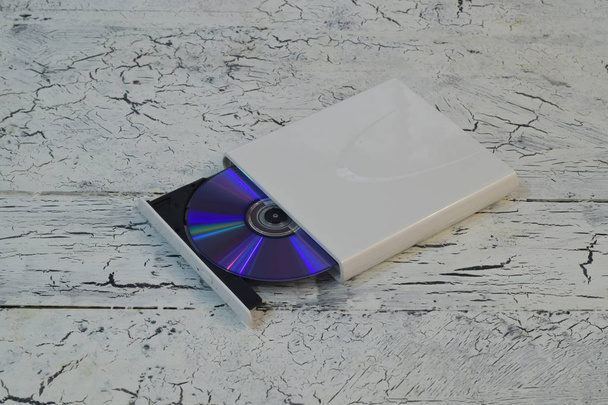 Externí Cd/Dvd/Blu-Ray disk s otevřený zásobník a fialové disk Blu-ray (Bd) na bílém pozadí dřevěná (pravý úhel pohledu) - Fotografie, Obrázek