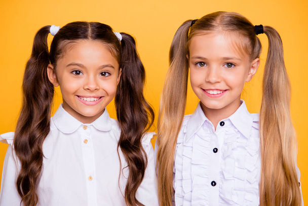 Close up portrait of beautiful, pretty, charming, gorgeous, adorable, good-looking small girls look directly at the camera isolated on shine yellow background - Valokuva, kuva