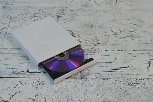 Ulkoinen CD / DVD / Blu-Ray-asema avattu tarjotin ja violetti Blu-ray (BD) levy valkoinen puinen tausta (vasen kulma näkymä
) - Valokuva, kuva