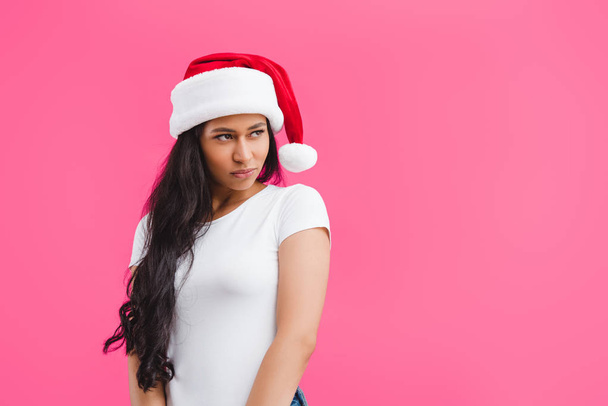 portrait of thoughtful african american woman in santa claus hat isolated on pink  - Photo, Image