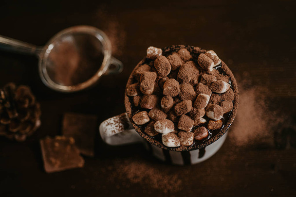 Гарячий шоколад з неглибокими цукерками, зимовий солодкий напій в кухоль на дерев'яному фоні, селективний фокус
 - Фото, зображення