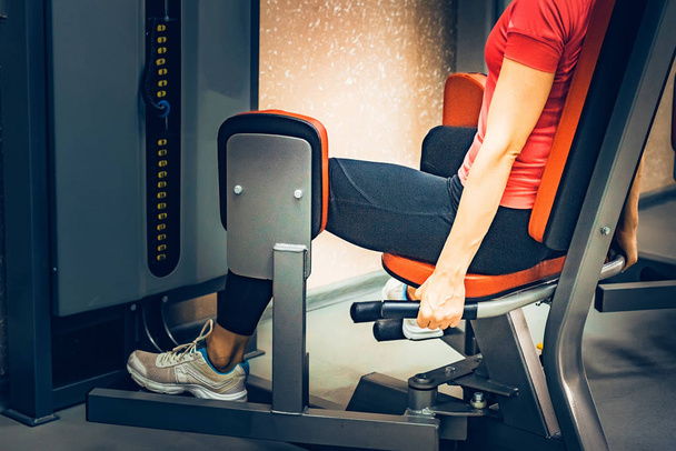 Jeune femme fait des exercices de jambes dans la salle de gym
 - Photo, image