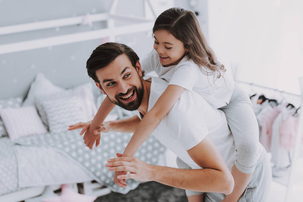Cute Young Daughter on Piggy Back Ride with Dad. Happy Father's Day Concept. Father with Daughter Spending Time Togetherness at Home. Happy Family Daughter Laughs on Holiday - Fotoğraf, Görsel