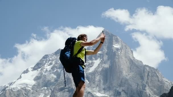 Ορειβάτης άνδρας με ένα σακίδιο που κάνει μια selfie σε ένα smartphone με διαφορετικά συναισθήματα. Έννοια της επιτυχίας, η επίτευξη των γκολ και νίκη, αργή κίνηση - Πλάνα, βίντεο