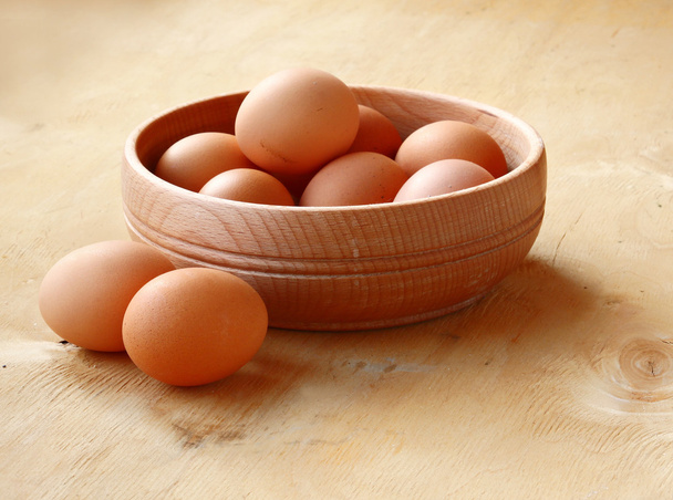 Десять домашних коричневых яиц на кухне
 - Фото, изображение