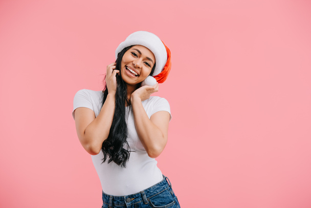 サンタ クロースの帽子ピンクの分離で幸せなアフリカ系アメリカ人女性の肖像画  - 写真・画像