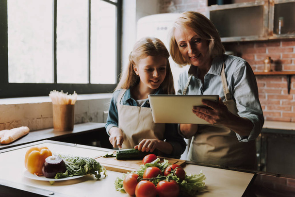 Cute Grandma and Granddaughter Cutting Vegetables. Grandma and Granddaughter Cooking Food. Vegetable Salad. Diet. Dieting Concept. Healthy Lifestyle. Cooking At Home. Prepare Food - Fotó, kép
