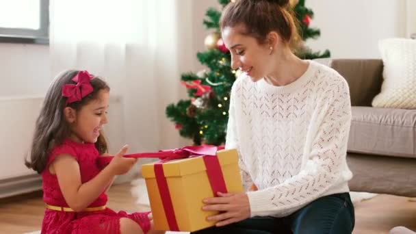 mother and daughter with christmas gift at home - Záběry, video