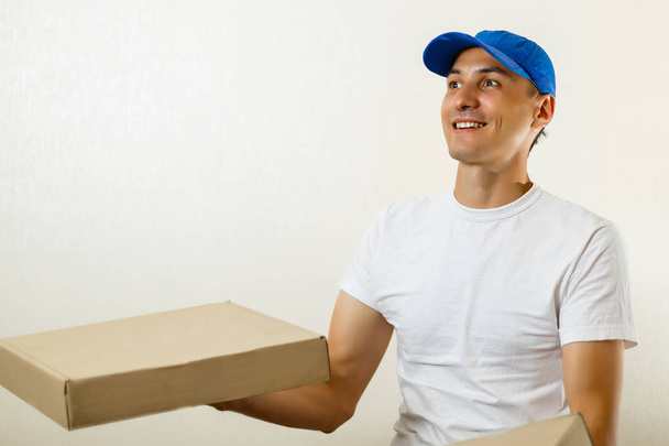 Delivery man with cardboard box on white background - Фото, зображення