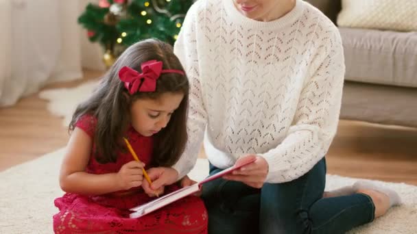 mother and daughter with notebook at christmas - Πλάνα, βίντεο