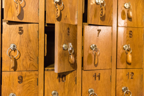 Деревянные ячейки с ключами для хранения мобильных телефонов в итальянском ресторане
 - Фото, изображение