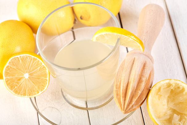 Freshly squeezed lemon juice. A glass of squeezed lemon juice and lemons around. Vitamins. Citrus fruits. Yellow. - Foto, Imagem