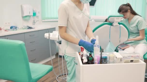 Assistant dentist prepares instruments before patients treatment in clinic - Кадри, відео