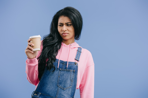 molesto joven afroamericana mujer con taza de café desechable aislado sobre fondo azul
  - Foto, Imagen