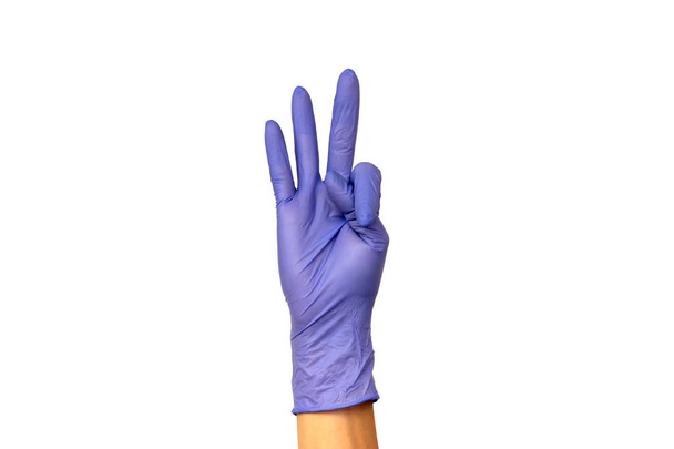 Vrouwelijke hand in een gekleurde rubberen handschoen. Isoleren op witte achtergrond. Het concept van het werk van een kok in een restaurant of een arts - Foto, afbeelding