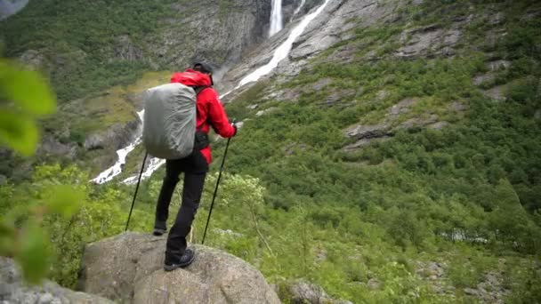 Valkoihoinen Backpacker nauttii Scenic Waterfall Vista Norjassa
. - Materiaali, video