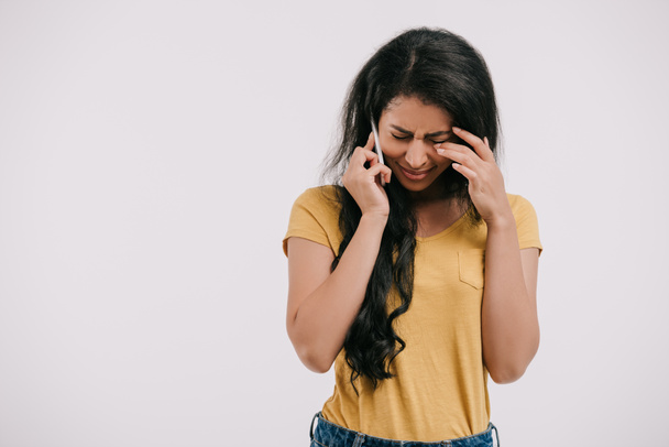 Afro-Amerikaanse meisje huilen en praten door smartphone geïsoleerd op wit - Foto, afbeelding