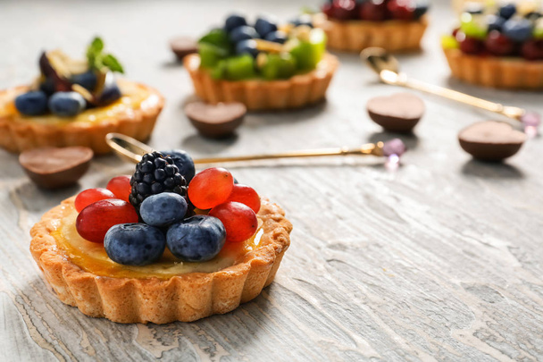 Delicious tart with berries on wooden table - 写真・画像