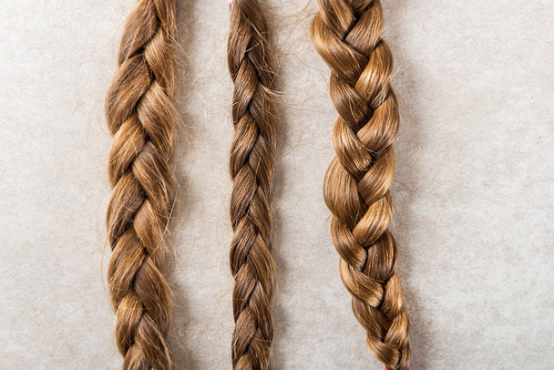 Wyciąć piękne długie włosy jako darowizny na cele charytatywne dla dzieci, co sprawia, że peruki dla chorych na raka, jasne tło - Zdjęcie, obraz
