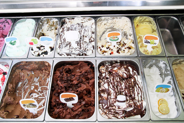 Jég krémes krém hűtőszekrény és olasz fagylalt acél szolgálja counter sok édes scoopable ízek frissítő gyümölcs. Ice cream bemutatás, gelato fagylalt különböző ízek. Cukrászda. - Fotó, kép