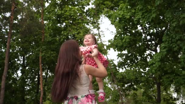 Mama zgłasza dziecko wysoko w powietrzu, śmiechu i zabawy z nią w parku. - Materiał filmowy, wideo