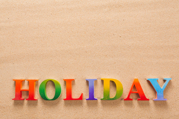 holiday written in colorful letters on the beach with copy space - Фото, изображение