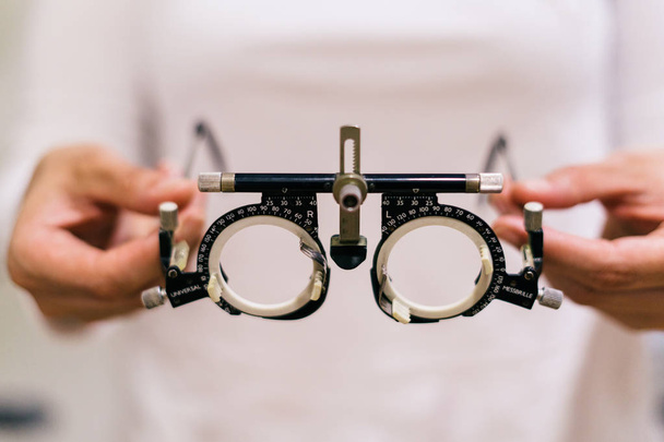 doctor hands holding optometrist trial frame to a patient. Checking vision concept. - Fotografie, Obrázek