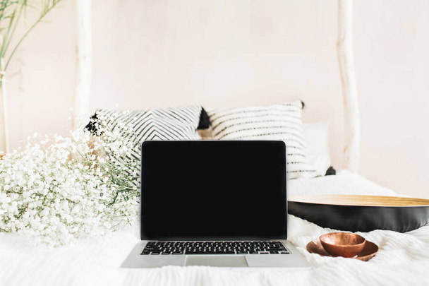 Freelancer werkruimte met laptop met leeg scherm, vintage schotel, witte bloemen. Vooraanzicht mock up sjabloon. Blog held kop concept. - Foto, afbeelding