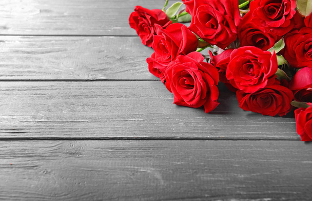 Beautiful bouquet of red roses on wooden background - Photo, Image