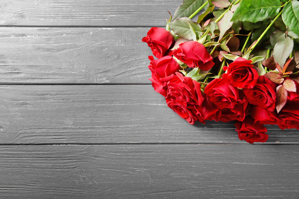 bellissimo bouquet di rose rosse su sfondo di legno - Foto, immagini