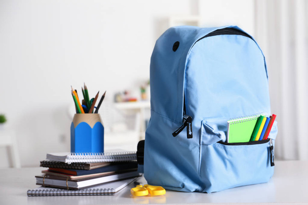 Backpack with school supplies on table - Foto, immagini