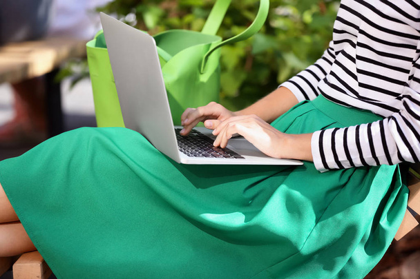 Beautiful young woman using laptop outdoors - Photo, Image