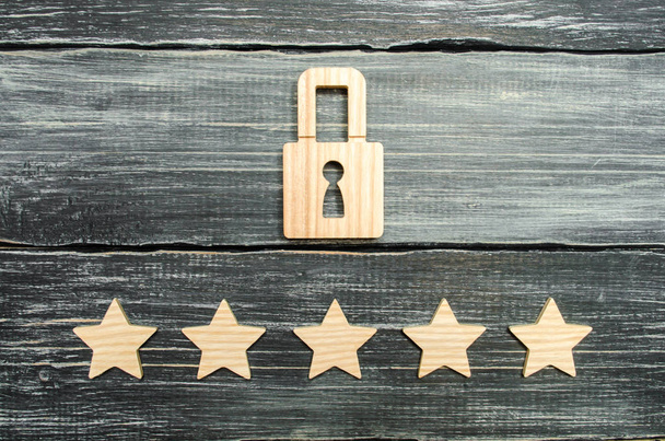 A wooden padlock and five stars. Security, security of users and business. Internet security, antivirus, data protection. Alarms of home, car and business. The concept of property protection. - Фото, зображення