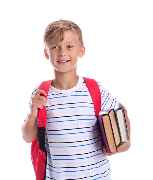 Cute little schoolboy with books on white background - Фото, зображення