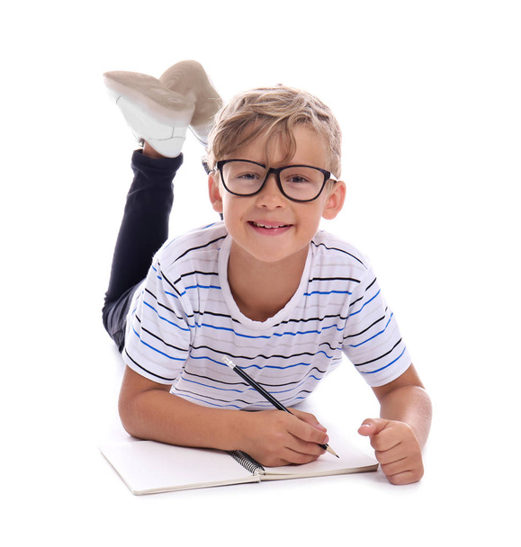 Cute little schoolboy doing homework on white background - Foto, Imagem